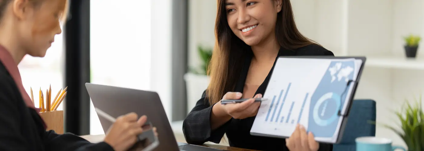 Sales professional presenting market insights and risk charts to a client, illustrating the Challenger selling strategy that creates urgent demand.