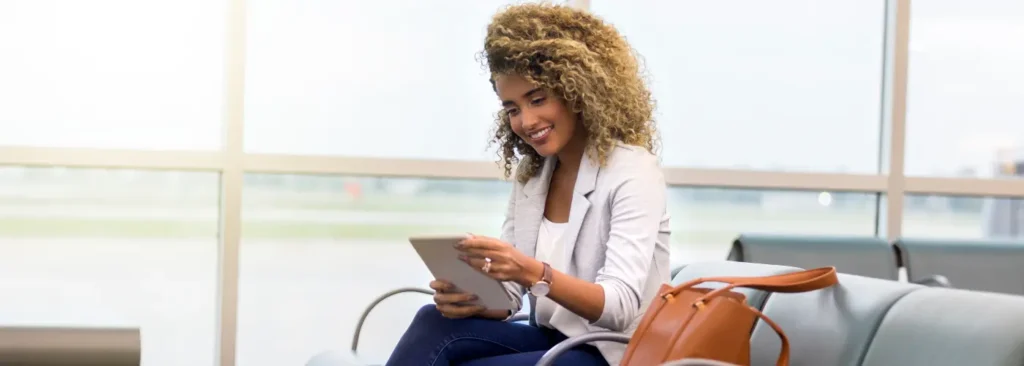 Business traveler reading a sales book on a tablet in an airport lounge during the Christmas holidays.