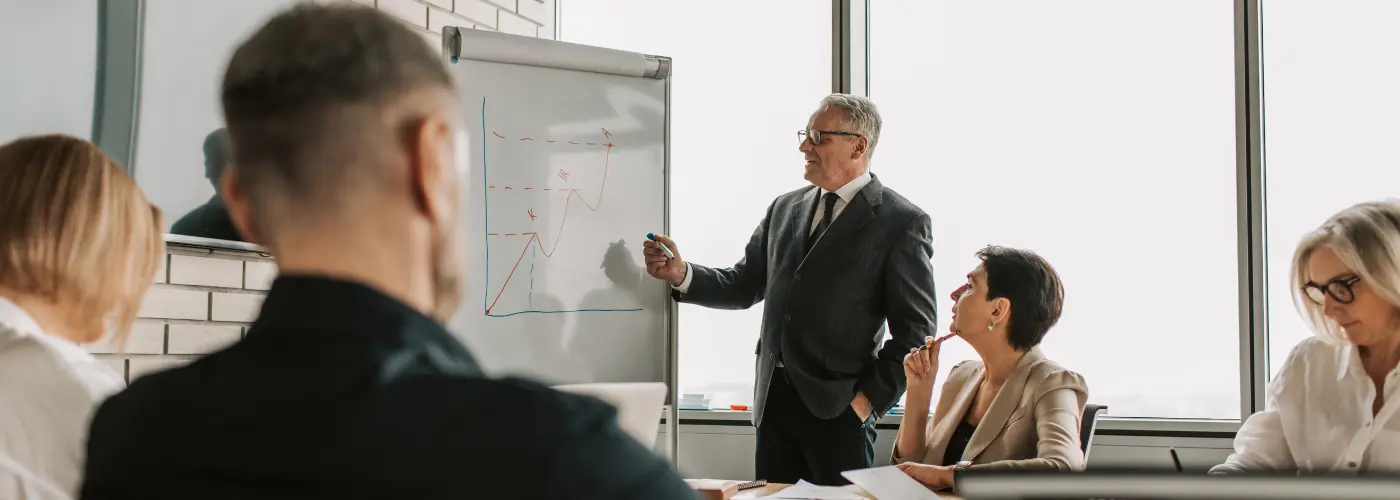 Sales leadership team reviewing different sales models on a whiteboard, clarifying the company’s sales doctrine. Sales Doctrine Ireland