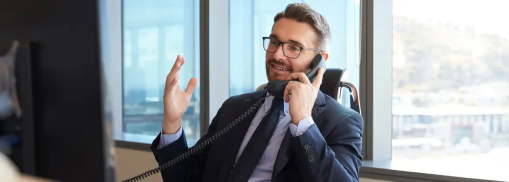 Sales prospecting call Sales professional sitting at a desk speaking on the phone during a business call in an office. Using sales prospecting resilience