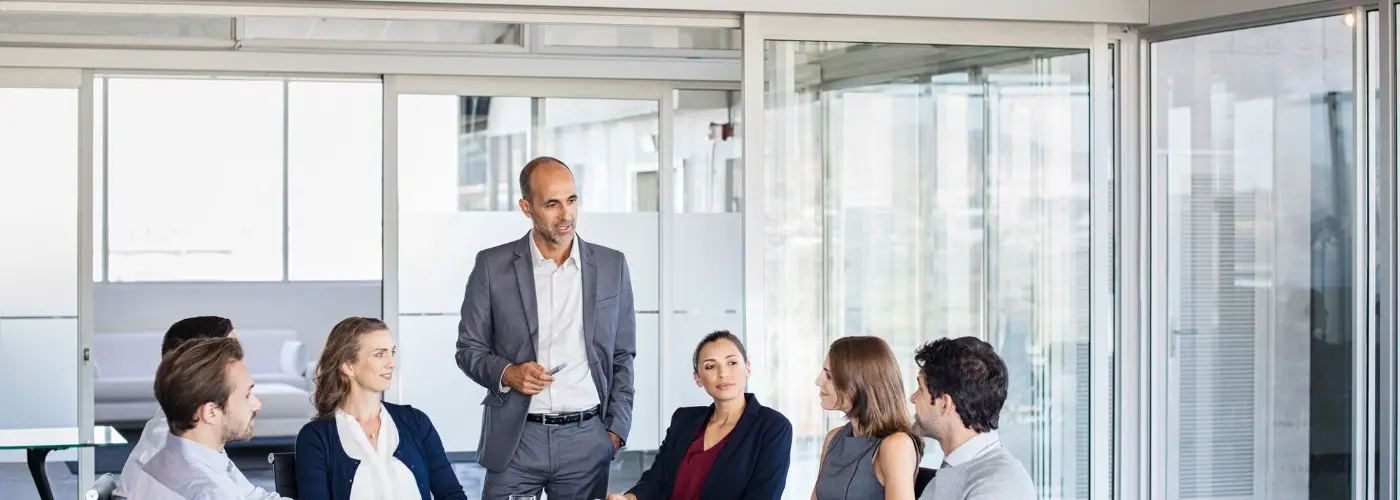 Sales trainer explaining Problem–Pain–Impact to a small group of B2B salespeople during a consultative selling workshop in Dublin.